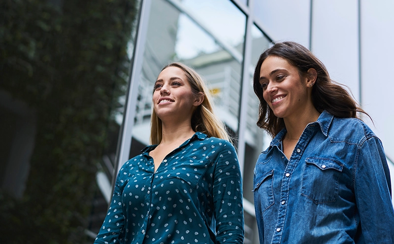 Two women walking with smiles